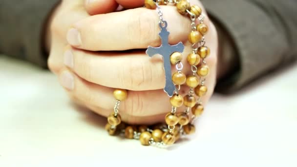 Hombre rezando sostiene en la mano rosario de madera con cruz — Vídeos de Stock