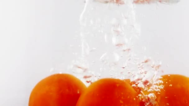 Rebanada de tomate cayendo en el agua — Vídeos de Stock