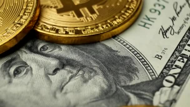 Moedas de ouro Bitcoin BTC girando em notas de 100 dólares — Vídeo de Stock