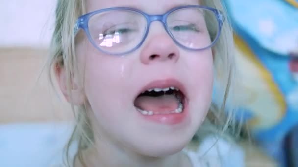 Egy kék szemű kislány szemüveg sír — Stock videók