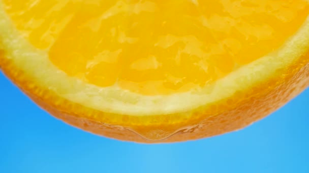 A drop of pure water or juice dripping from a slice of orange — Stock Video