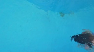 Su altında mavi bir mayo güzel kadın yüzüyor