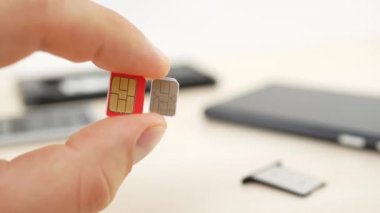 Bir kırmızı mikro Sim ve beyaz nano SIM kartları tutan el