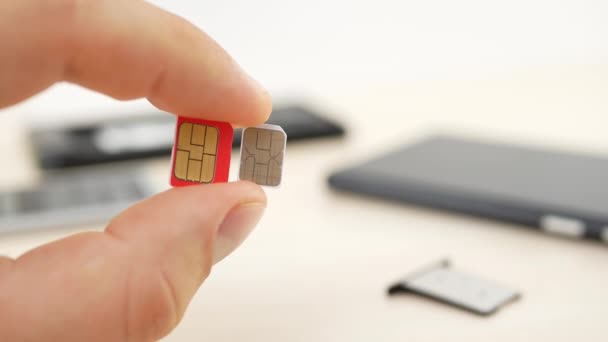 Hand som håller en röd micro Sim och vit nano SIM-kort — Stockvideo