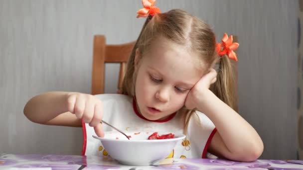 Little girl eats a spoon with a white bowl — Stock Footage Little girl eats a spoon with a white bowl Stock Video