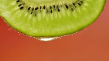 Bir dilim kivi saf su veya meyve suyu damlayan bir damla