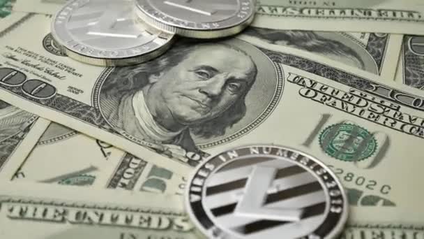 Moedas Litecoin LTC girando em notas de 100 dólares — Vídeo de Stock