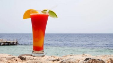 Mavi ve turkuaz deniz arka plan veya okyanus üzerinde kırmızı çilek ve mango suyu
