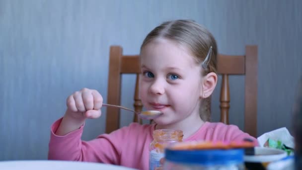 Entzückende glückliche Kind Mädchen essen frisches Fruchtpüree — Stockvideo