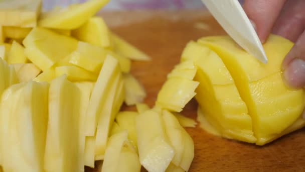 Las manos femeninas cortan la patata dulce con un cuchillo en la tabla de cortar — Vídeos de Stock