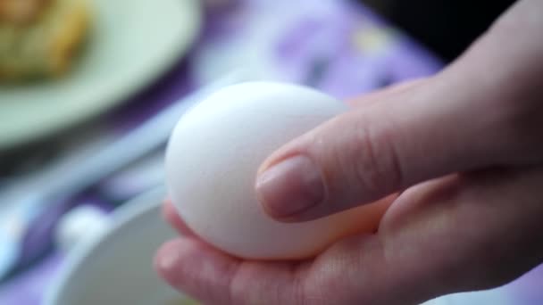 Vrouw breekt ei in een witte schaal — Stockvideo