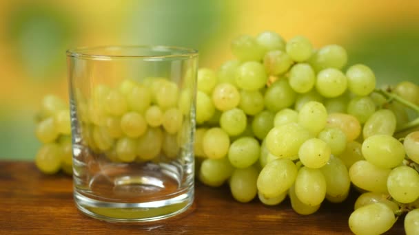 Juice Pours into Glass with Organic White Grapes on Table — стоковое видео