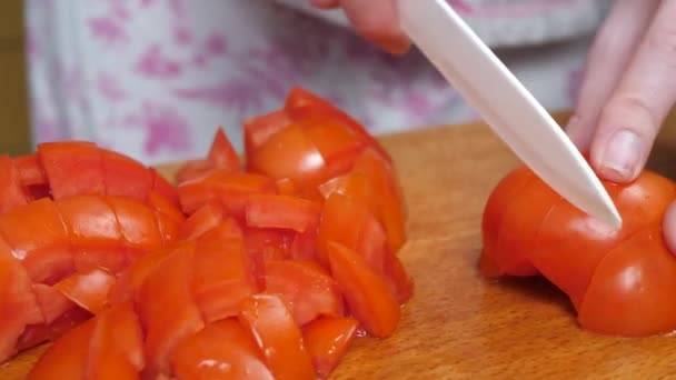 Frau schneidet Tomaten mit Messer auf Schneidebrett — Stockvideo