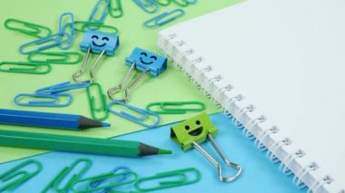 Not Defterine Yeşil ve Mavi Ofis Kağıt Kıskacı, Gülümseyen Bağlayıcı ve Kalemler