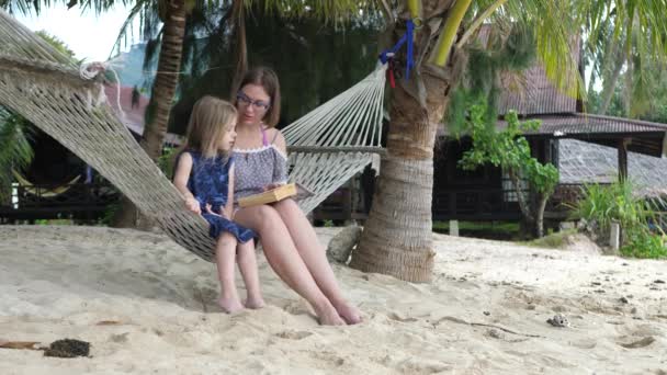 Madre e hija se sienta en libro de historias de las lecturas de la hamaca — Vídeos de Stock