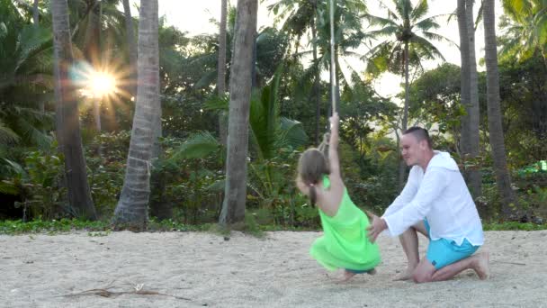 Pequena filha cavalgando em Makeshift Swing na praia — Vídeo de Stock