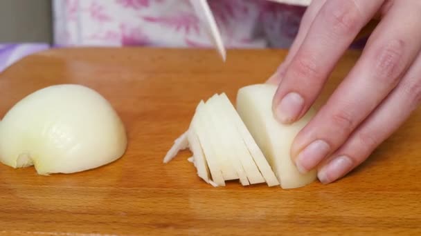 Donna che taglia cipolla bianca su tavola di legno — Video Stock