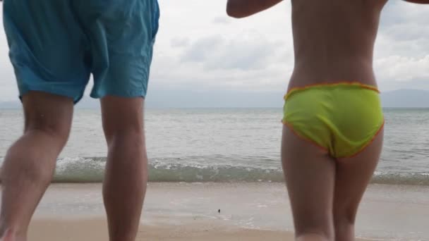 Filha, pai e mãe correm na praia de areia — Vídeo de Stock