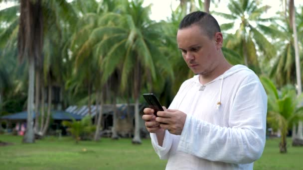 Jóképű férfi tartja Smartphone a kezében és gépelés üzenet — Stock videók