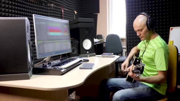 Gitarr spelare spelar in ljudet av instrument i studion — Stockvideo
