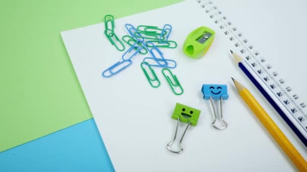 Office Paper Clip, Smile Binder Clips en potloden op notitieblok — Stockvideo