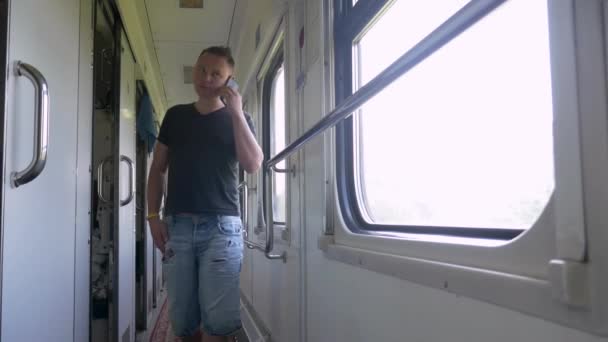 Jongeman in de trein met mobiele telefoon conversatie — Stockvideo