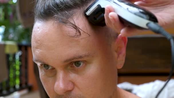 Жіночий перукар створює стилістичну зачіску для чоловічого кузомеру з професійною чорною електрикою. — стокове відео