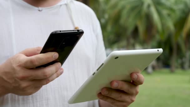 Mężczyzna używa tabletu PC i smartfona — Wideo stockowe