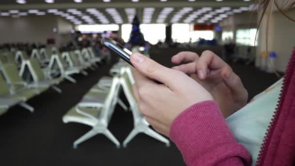 Női kézi használatra okostelefon a repülőtéren. Utazási vakáció és hálózati koncepció — Stock videók
