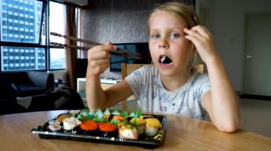 Suşi menüsünün değişik sıralarını yiyen tatlı genç kız.