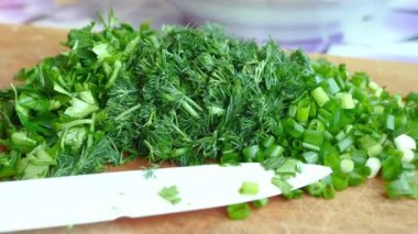 Chopped Soup Greens And White Ceramic Knife On Brown Wooden Cutting Board
