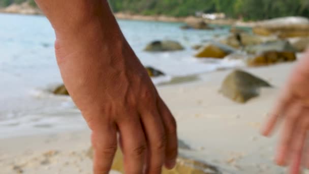 Coppia che si tiene per mano sulla spiaggia di sabbia — Video Stock