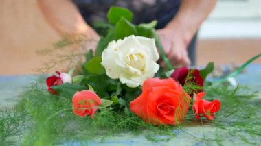 Making bouquet of pink, white and red roses