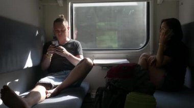 Yolcular yolcu vagonunda akıllı telefon kullanırlar.