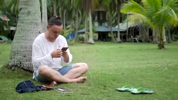 Surpreendido engraçado masculino sorrisos usando smartphone preto — Vídeo de Stock