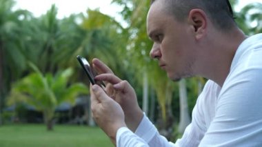 Guy Holding Smartphone and Looking at Screen and Reading SMS