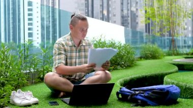 Male Checks Documents And Inputs Data In Laptop Computer