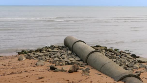 Residuos industriales de tuberías en el mar en la playa de arena — Vídeo de stock