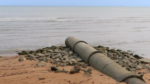 Pipeline industrial waste into sea on sand beach