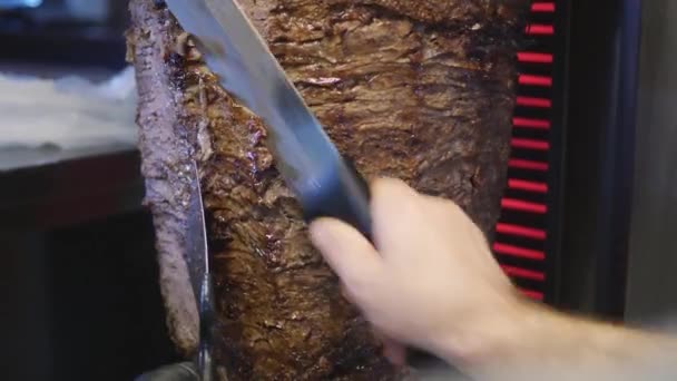 Cooking chawarma or shaurma roasted on slowly-turning vertical rotisserie or spit — Stock video