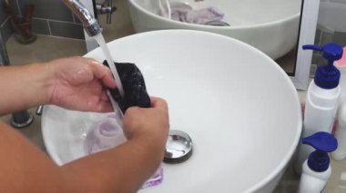 Erkek elleri bireysel yüz maskelerini yıkar.