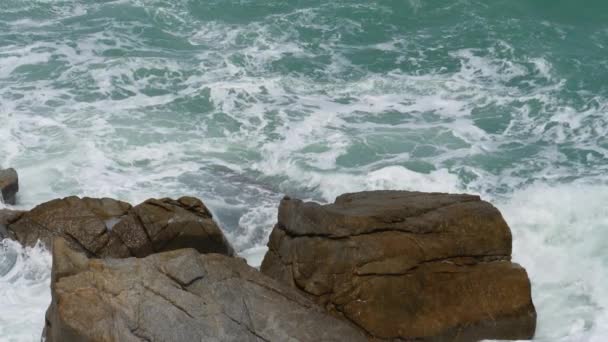 Rullande våg smäller på klipporna vid kusten — Stockvideo