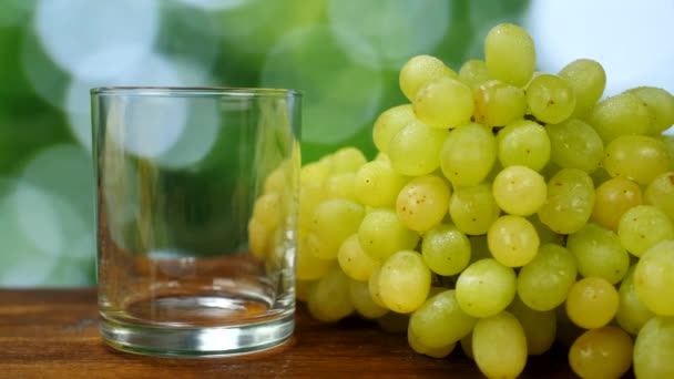 Свежий виноградный сок на деревянном фоне — стоковое видео