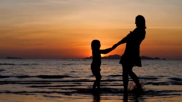 Happy fille et mère silhouette danse sur le coucher de soleil dramatique — Video