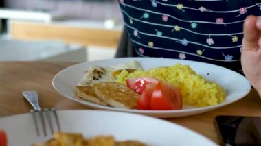 Tanınmayan bir kadın soya sosunu tofunun üzerine sürüyor.