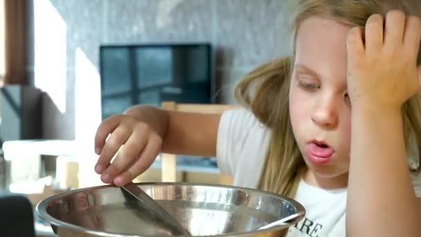 Menina bonito miúdo com cabelo bonito Grimacing comer sopa com colher de tigela metálica dentro do quarto — Vídeo de Stock