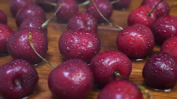 Gotas de água cai em cerejas vermelhas escuras suculentas maduras doces — Vídeo de Stock