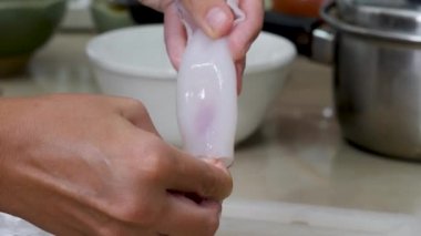 Kadın kalamarı elinde tutuyor.