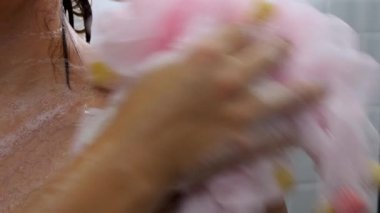 Güzel bir kadın seramik seramik duvarda duş alır.