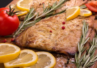 Limon, biberiye, domates, sarımsak dilimleri ile fırında uskumru,